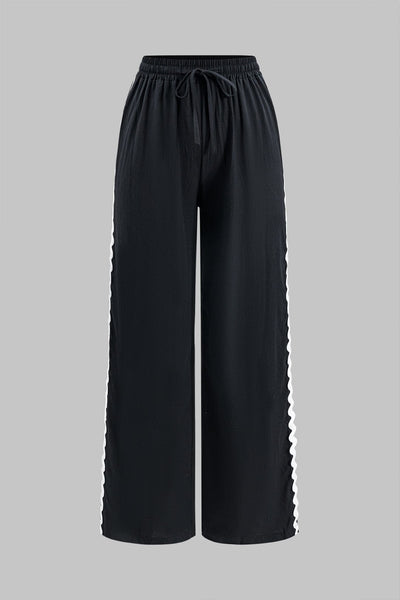 Ensemble élégant deux pièces avec top froncé et pantalon large noué.