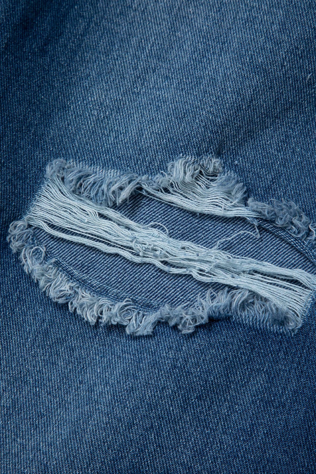 Jean en denim déchiré avec zip, effet usé et coupe ajustée. Pantalon tendance pour un style casual et urbain.
